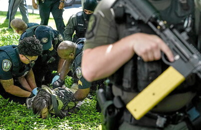 Policías detienen a un manifestante en una protesta en la universidad de Emory de Atlanta, Georgia.